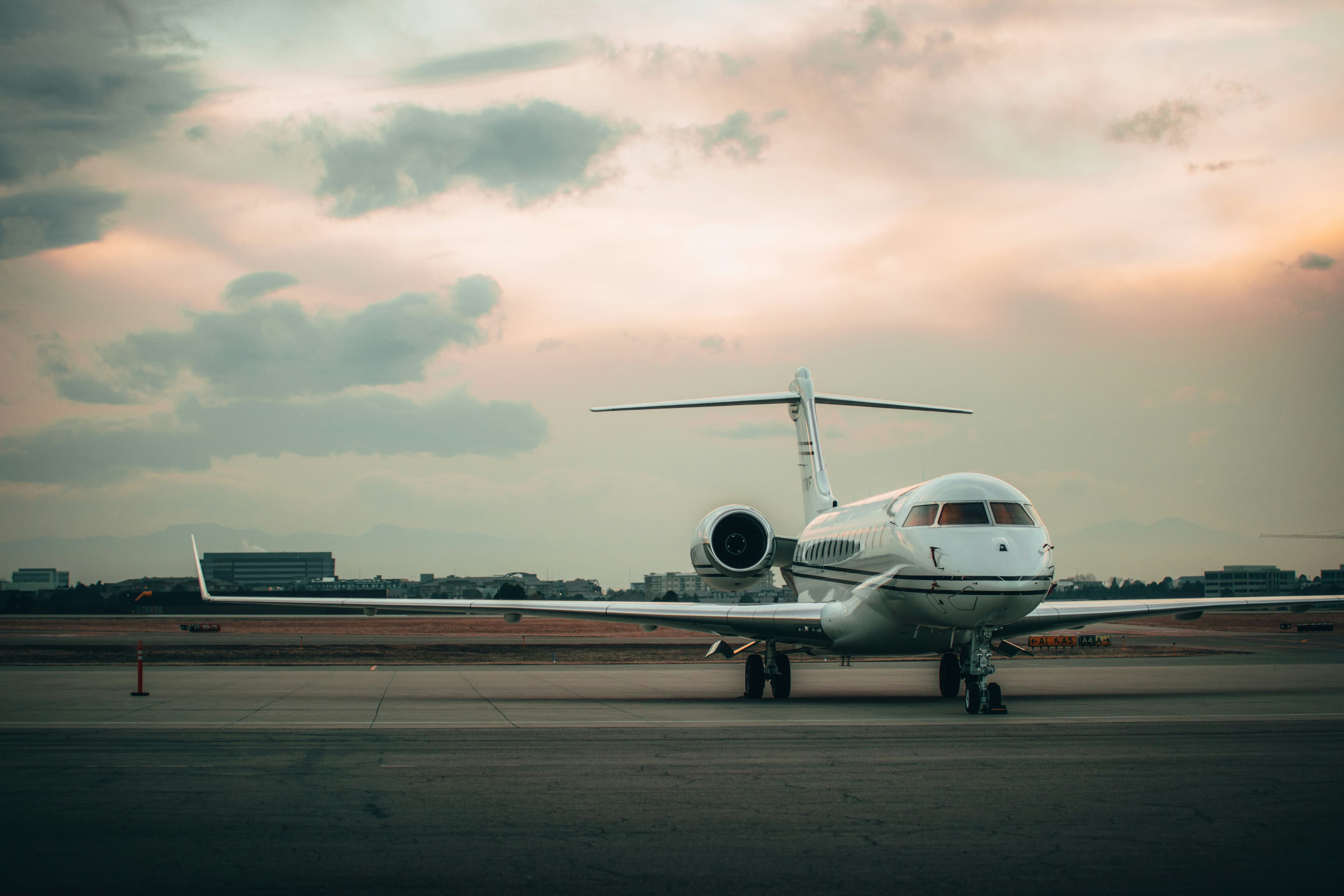 Private jet on the tarmac with Mediterranean coastline in the background